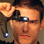 A pixelated close-up of a person wearing dark sunglasses with reflective lenses, holding a large light-colored flower near their face.