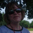 Pixelated image of a person with short brown hair and sunglasses in a blue shirt, next to cyan text on black background.