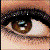 A pixelated close-up of a human eye with brown iris, black eyelashes, and light skin tones under warm lighting.