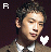 A pixelated image of a person in a brown jacket with white shirt and tie, featuring text 'R' on left side and 'ain' on right side.
