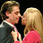 A static image shows a man and woman in close proximity on a pink background with pixelated text.