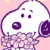 Pixelated cartoon character with white body, purple outline, and pink background holding a flower-like object in one hand.