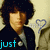 A person with dark curly hair wears a dark jacket over light clothing, standing against a beige background with blue heart outlines; text changes from 'just' to 'so' and 'cute' appear in cyan.