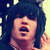 Static pixelated image of a person with dark hair and an open mouth expression against a light background.