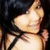 Pixelated static image of a light-skinned figure with dark hair wearing a white top and black bow, set against a dark background.