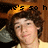 A pixelated image of a person with curly brown hair wearing a yellow cap and light-colored shirt, with partial text above the head.