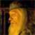 Pixelated side profile of a figure with long flowing hair, wearing a crown, set against a dark background with brown architectural elements.
