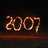 Pixelated brown numerals '2007' on dark background with horizontal brown bar beneath.