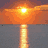 Sunset over water with reflection, text reading "I can't wait till summer..." on teal background, black flip-flops on sand, and "All Clear Water Beach Florida!" text.
