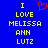 Blue background with yellow pixelated text reading "I LOVE MELISSA ANN LUTZ" and a red heart symbol above the word "LOVE", displayed in two identical side-by-side