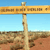 A pixelated signpost with multiple directional signs against a clear blue sky and arid landscape background.