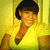 Pixelated image of a person with short dark hair wearing a yellow shirt against a yellow background.