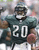 Pixelated image of a football player in dark green jersey with white number 20, holding a brown football, wearing helmet and shoulder pads.