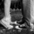 Black-and-white photo of a person's lower legs and feet in shoes on grass, with red text overlays reading "i LOvE yU LoZa" and date stamp "*9-10-07".