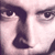 Pixelated close-up of a face showing eyes, nose, and part of a mouth with dark hair and light skin tones.