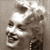 Pixelated grayscale image of a stylized human skull with visible teeth and eye sockets, rendered in low-resolution 256x256 pixels on a neutral background.