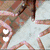 Animated icon shows hands forming a heart shape around a glowing object with white hearts floating upward against a dark background.