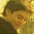 Static 48x48 pixel icon showing a close-up of a person's face with brown hair and yellow-toned skin, rendered in low-resolution pixel art style against a golden-yellow background.