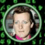 Static 64x64 pixel icon featuring a person with brown hair in a circular frame, pink collar visible, green patterned background.