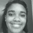 Pixelated grayscale portrait of a person with dark hair, neutral expression, and visible teeth in a smile.