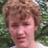 A pixelated image shows a person with light brown hair against green foliage, overlaid on red background with pink text.