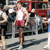A pixelated animation of a person in red shorts and white shirt running on a track with spectators behind.