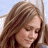 A 48x48 pixel buddy icon split into two sections: a left-side portrait of a person with long brown hair and closed eyes against a light blue background, and a right-side green section with bright green text reading "Original Icons .com" in a stylized font.