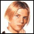 Pixelated static image of a person's head and shoulders with light brown hair, visible facial features including eyes, nose, mouth, and ear, against a white background.