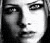 Black-and-white pixelated image of a person's face next to text reading 'avril kicks ass' on dark background, with lower version showing same text on gray background.