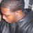 Pixelated close-up of a person's face with closed eyes, wearing dark clothing and light-colored hair.