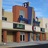 Pixelated static image of a multi-story building with brown, blue, and white sections under a light blue sky.