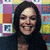 A person with dark hair in three poses against a colorful background, smiling and tilting the head