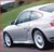 A silver sedan with visible wheels and windows, positioned on a road with greenery in the background.