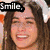 A person with long brown hair smiles in three distinct pixelated views, each showing different text overlays and background colors.