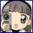 Pixelated anime-style character with short brown hair, large eyes, and a pink mouth, holding a gray device against a light background.