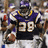Pixelated image of a football player in purple and gold uniform holding a brown football, number 29 visible on jersey.