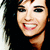 Pixelated close-up of a smiling person with dark hair, red lips, and visible teeth against a black background.