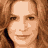 Static image featuring red text on black background with partial face of woman with light brown hair in top-left corner.