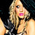 Pixelated image of a person with long blonde hair holding a microphone, wearing a dark sleeveless top against a dark background.