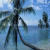 Pixelated static image of a dark figure with multiple limbs against blue sky and water background.