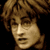 Pixelated close-up of a person with light brown curly hair against dark background, showing two sequential facial expressions.