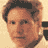 Static pixelated image of a person's face with brown hair and light skin tone on a beige background, rendered in low-resolution 256x256 pixels.
