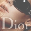 A close-up of a person with light skin and blonde hair wearing dark sunglasses, with the text 'Dior' overlaid in large white letters.