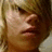Pixelated close-up of a person's face with light brown hair, showing eyes closed and lips slightly parted against a blurred background.