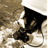 Pixelated image of a dark triangular shape with lighter brown and white areas surrounding it on a textured background.