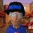 Pixelated static image of a person wearing a black helmet with blue and pink accents, silver glasses, and a blue shirt against an orange-brown background.