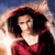 A pixelated image of a person with dark hair wearing a red top, set against a blurred background with light and dark tones.