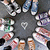 A static pixelated image shows a central heart shape surrounded by eight distinct character icons arranged in a circular pattern against a dark gray background.