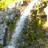 Six colored letters arranged in two against a blurred waterfall background, with no visible motion