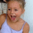 Pixelated image of a person with light brown hair wearing a white tank top, mouth open in an expressive gesture against a pale blue background.